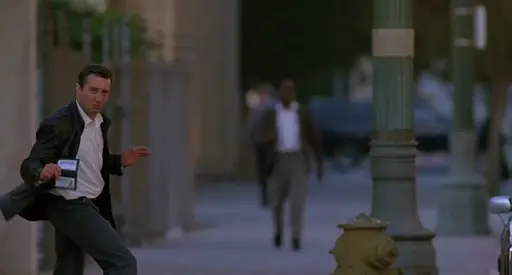 A man on a street spins round to display an FBI badge.