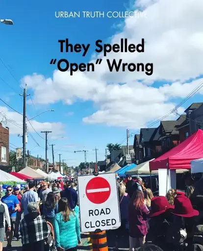 Text overlaid says "They Spelled 'Open' Wrong" featuring a crowded street market with people walking among vendor tents. A "Road Closed" sign is at the center