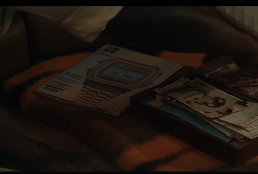 captura de la serie Alien Earth, con una revista (o catálogo) donde sale un reloj digital de color oro tanto la caja como la correa